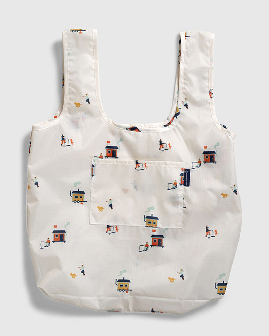 Tusk The Packable Tote (Flat-lay): White tote with small ice fishing hut and dog print, front pocket visible