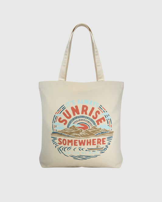 It's Always Sunrise Somewhere My Favorite Daily Tote (Front): Natural canvas tote with circular sunrise mountain scene graphic and shoulder straps