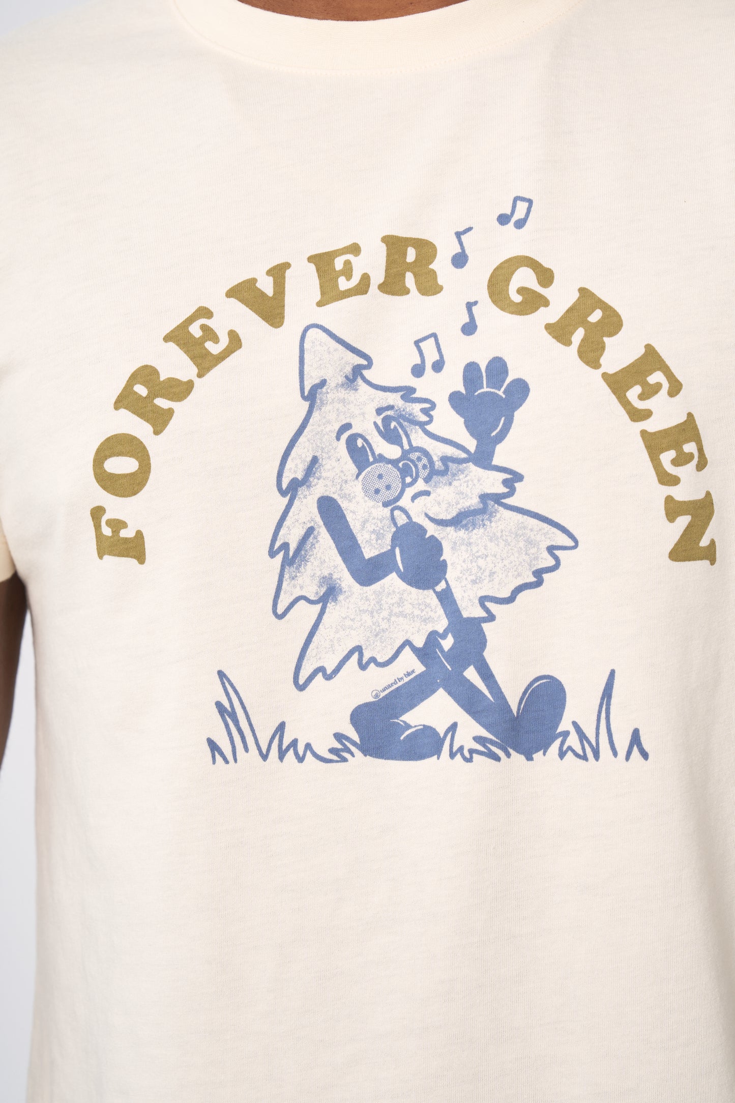 Shortbread Forever Green Graphic Tee (Detail): Cream tee with blue cartoon singing tree and olive arc text