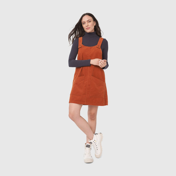 Ginger Corduroy Overall Dress (In-use): Rust corduroy pinafore with front pockets, worn over dark turtleneck