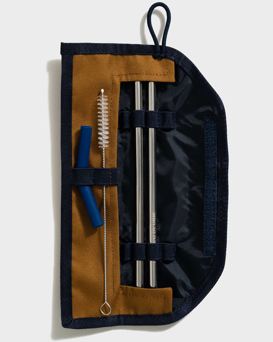 Camel The Straw Kit (Flat-lay): Open navy roll case with two steel straws, brush, and blue tip