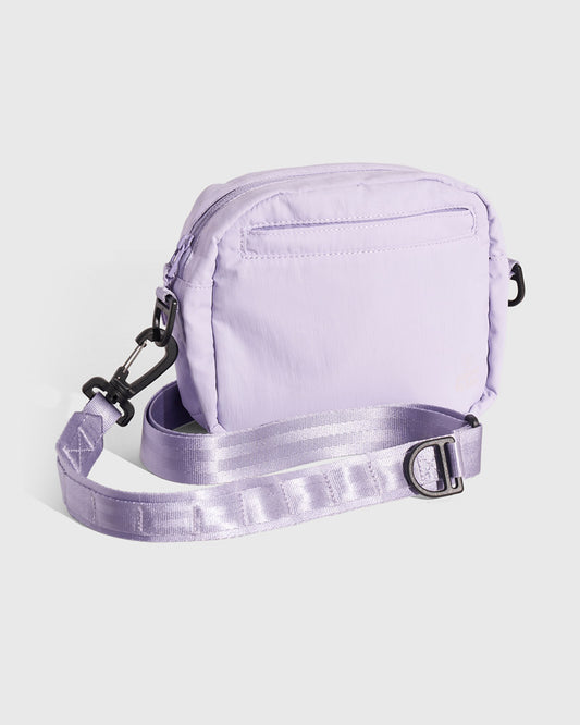 Lavender (Re)active™ 2L Convertible Crossbody (Angle): Light purple crossbody bag back view with adjustable strap and black hardware