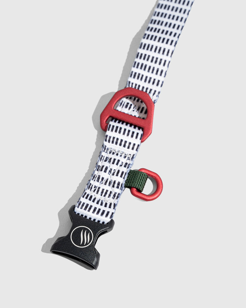 Shortbread (R)evolution™ Recycled Woven Dog Collar (Detail): White woven strap with black dashes, red D-rings, black buckle clip