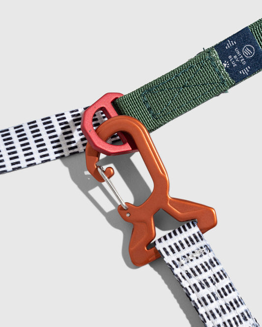 Shortbread (R)evolution™ Recycled Woven Dog Leash (Detail): Orange and red carabiners clipping a striped white leash to green webbing