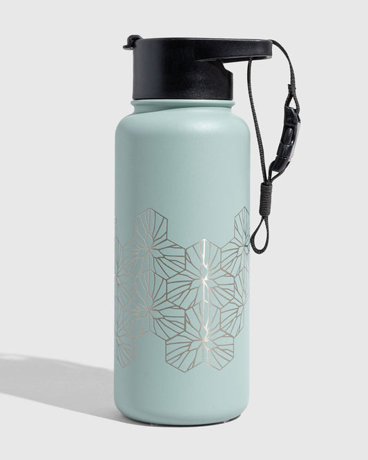 Juniper Insulated Steel Bottle 32 Oz. (Angle): Mint green steel bottle with silver geometric hexagon pattern and black lid
