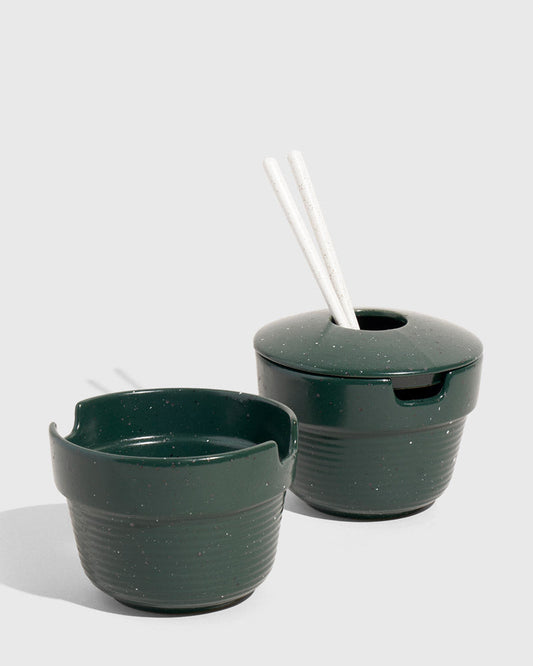 Pine Stoneware Stackable Noodle Bowl Set (Angle): Two dark green speckled stoneware bowls, one lidded with white chopsticks inserted