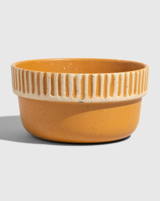 Caramel Stoneware Stackable Bowl (Angle): Round ceramic bowl, warm amber glaze, cream ribbed textured upper band