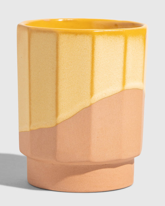 Honey 8 oz. Stackable Stoneware Tumbler (Angle): Faceted tumbler with yellow glaze dripping over unglazed terracotta base