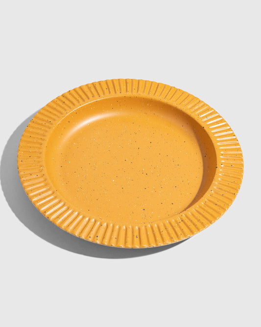 Caramel Stoneware Stackable Plate (Angle): Round golden-yellow speckled plate with ribbed scalloped rim, shallow well