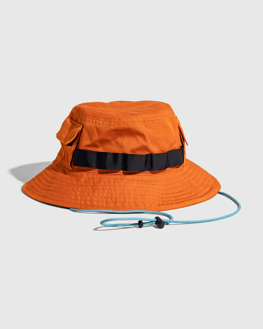 Tangerine Organic Bucket Stash Hat (Angle): Orange boonie hat with black webbing band, side pockets, and blue chin cord