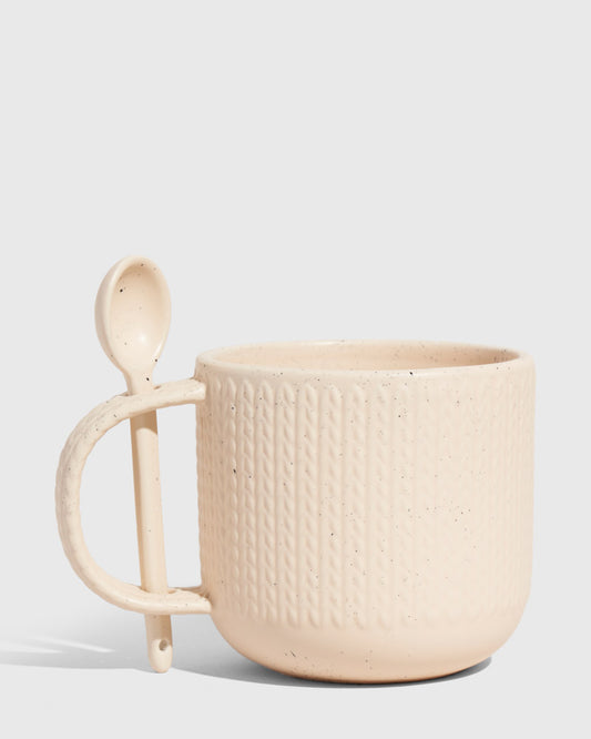 Shortbread 14 oz. Stoneware Spoon Mug (Angle): Cream speckled stoneware mug with knit texture and attached ceramic spoon holder