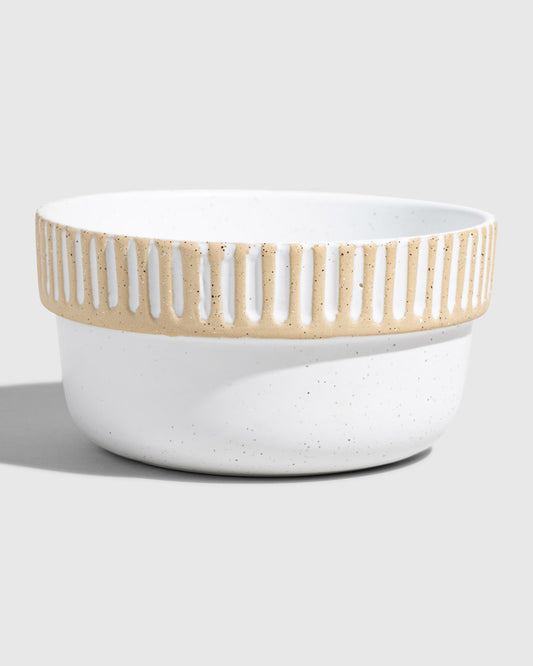 Eggshell Stoneware Stackable Bowl (Angle): Round white speckled ceramic bowl with carved vertical stripe band near rim