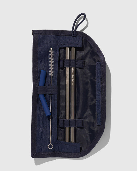 Navy The Straw Kit (Flat-lay): Open navy roll case displaying two metal straws, cleaning brush, and silicone tips