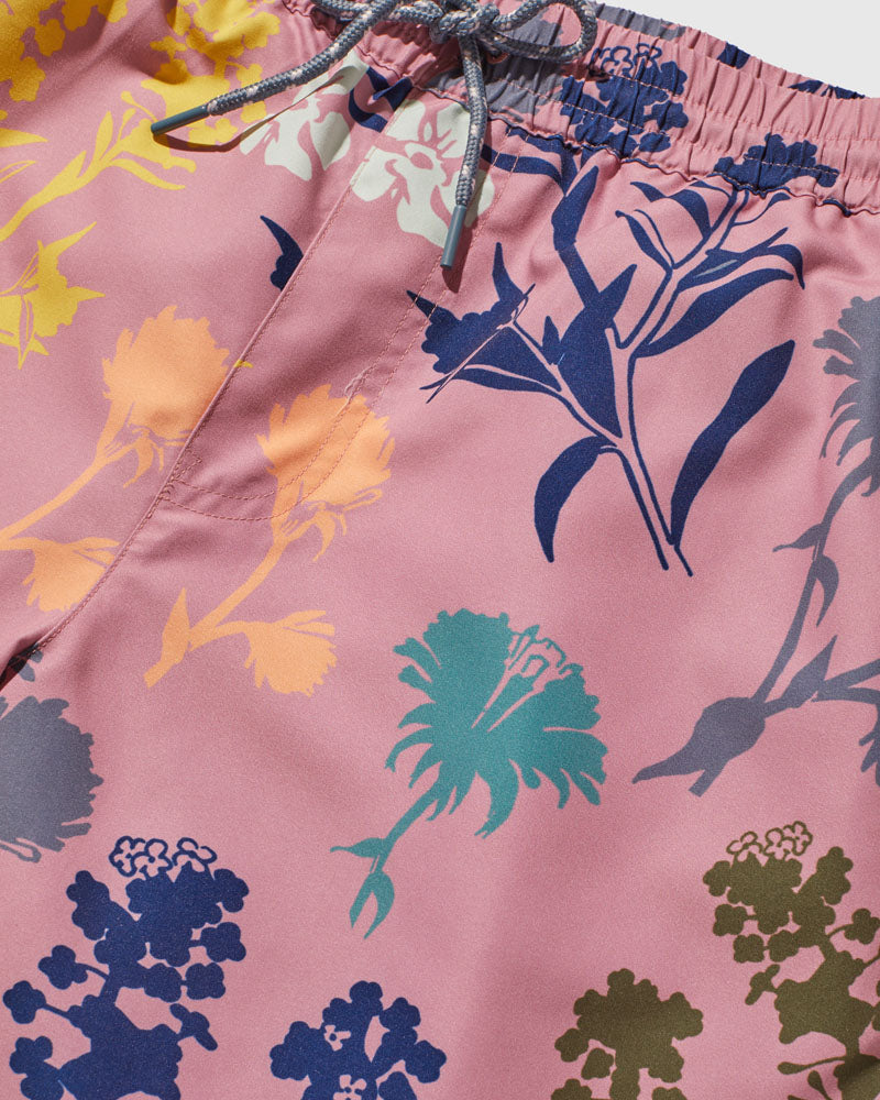 Foxglove Recycled Swim Trunk - 5" (Detail): Pink fabric with multicolor floral silhouettes in blue, teal, yellow, and olive