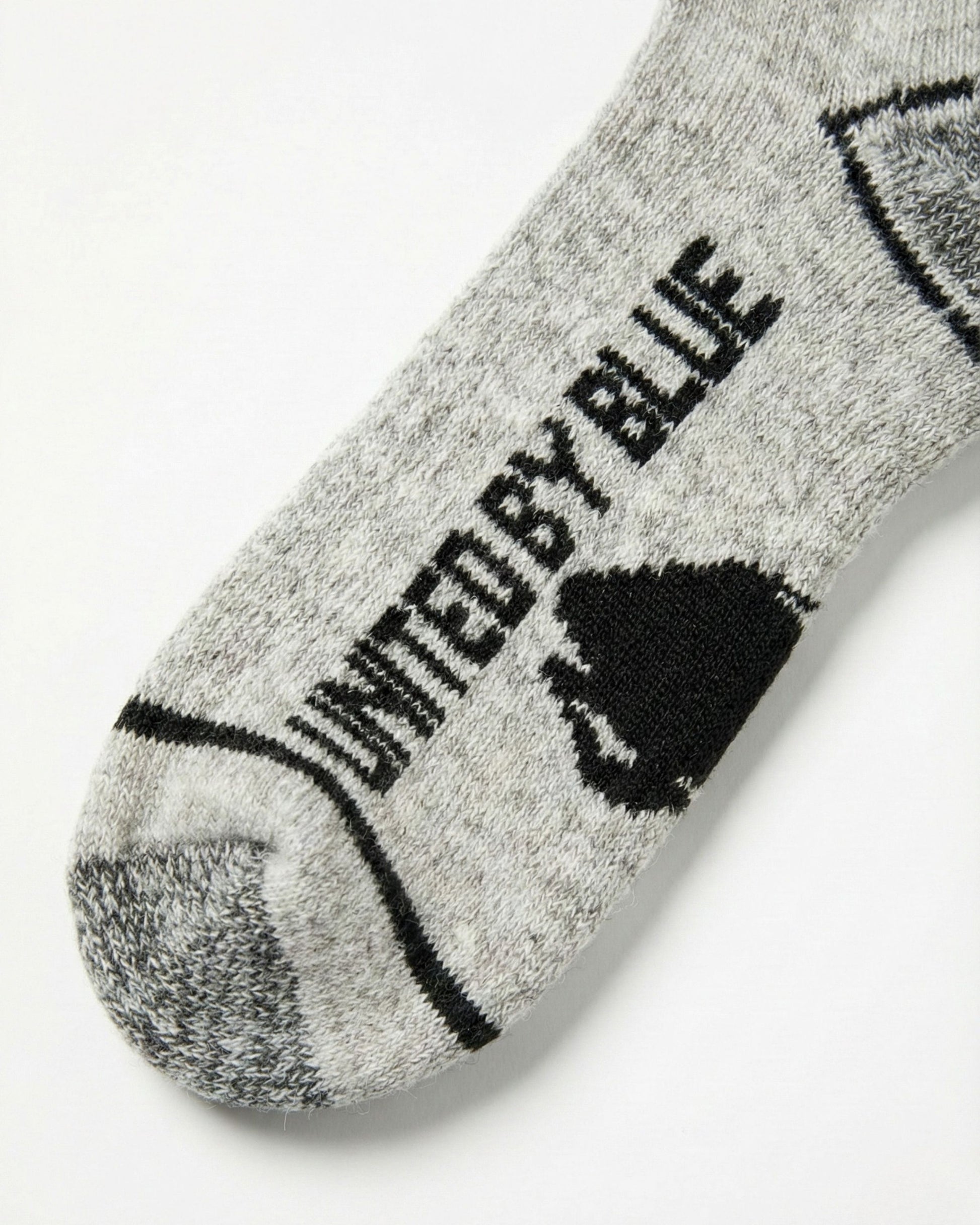 Ultimate Bison Boot Sock - Imperfect Packaging (Detail): Close-up of gray sock toe with black United By Blue logo text