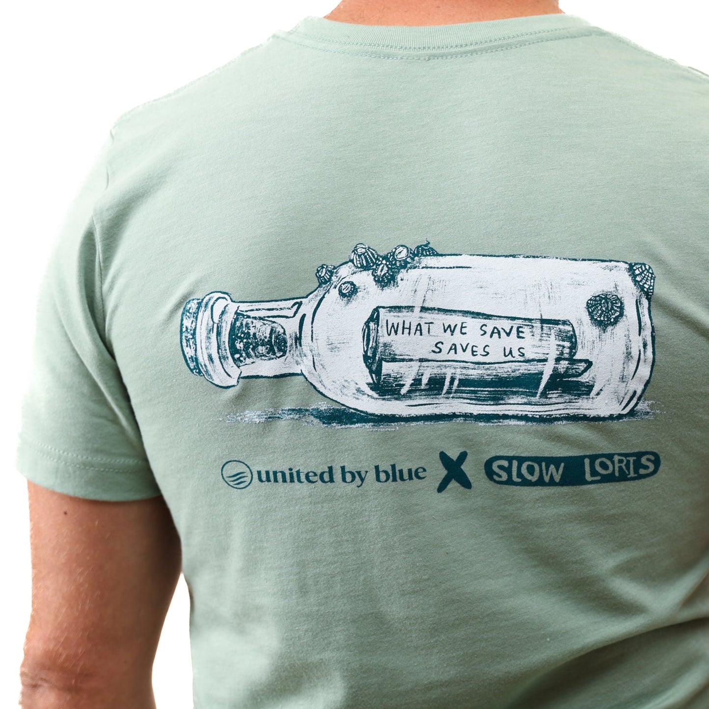 Heather Sage What We Save Graphic Tee - Slow Loris x United By Blue (Detail): Back of sage green tee with bottle graphic and conservation message