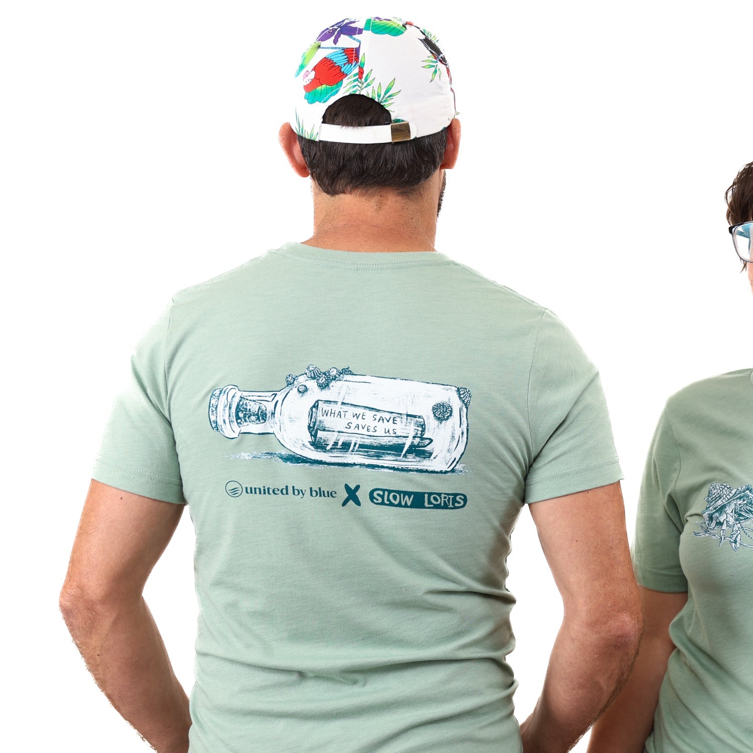 Heather Sage What We Save Graphic Tee - Slow Loris x United By Blue (Back): Sage green tee back with bottle graphic reading 'What We Save Saves Us'