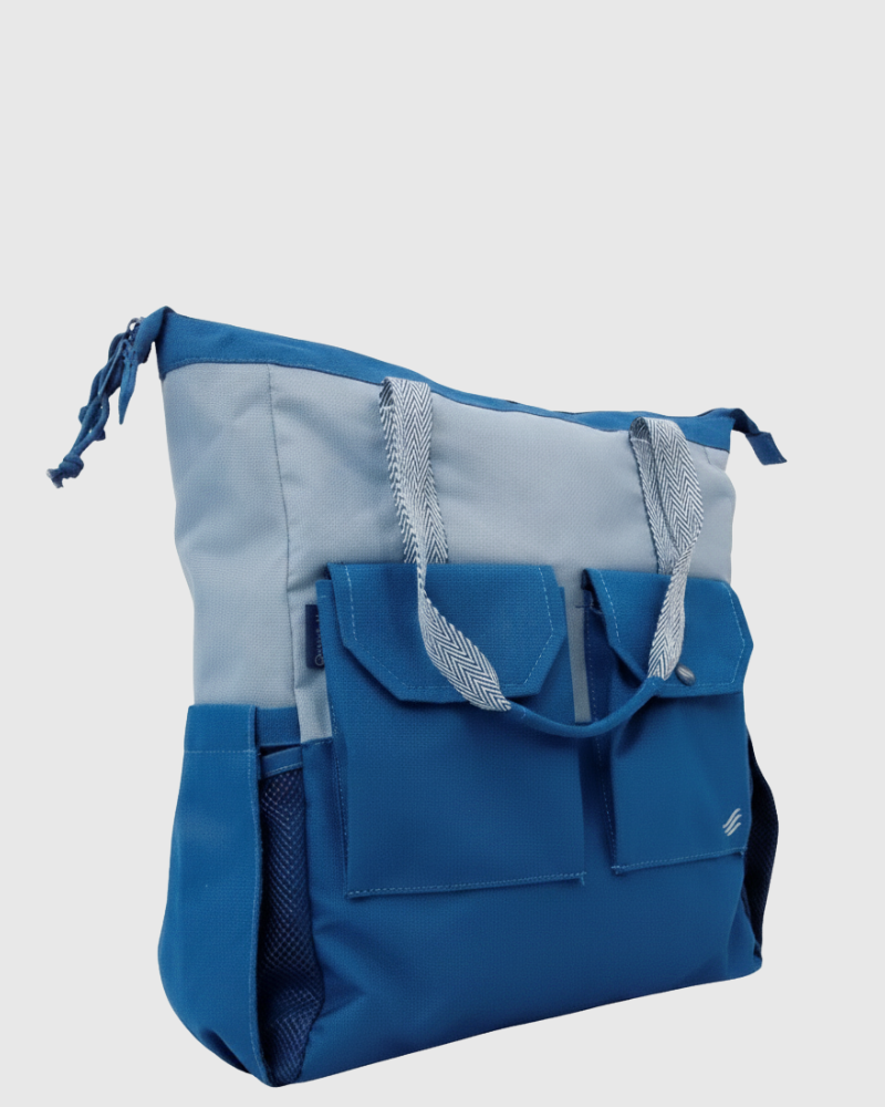 Blue (R)evolution™ 27L Utility Convertible Tote (Angle): Two-tone blue tote with front flap pockets, herringbone handles, side mesh pocket
