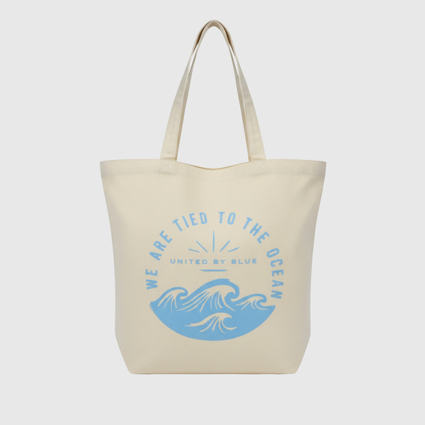 We Are Tied To The Ocean My Favorite Daily Tote (Front): Cream canvas tote with blue ocean waves and arched text graphic