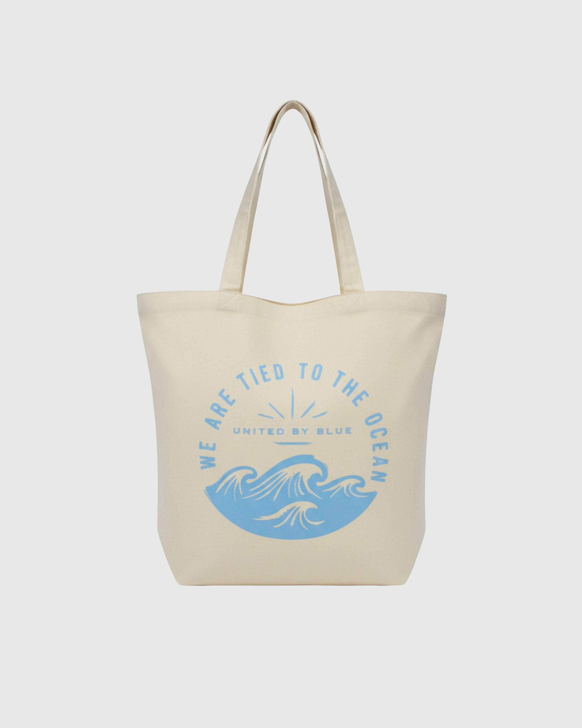 We Are Tied To The Ocean My Favorite Daily Tote (Front): Cream canvas tote with blue ocean waves and arched text graphic