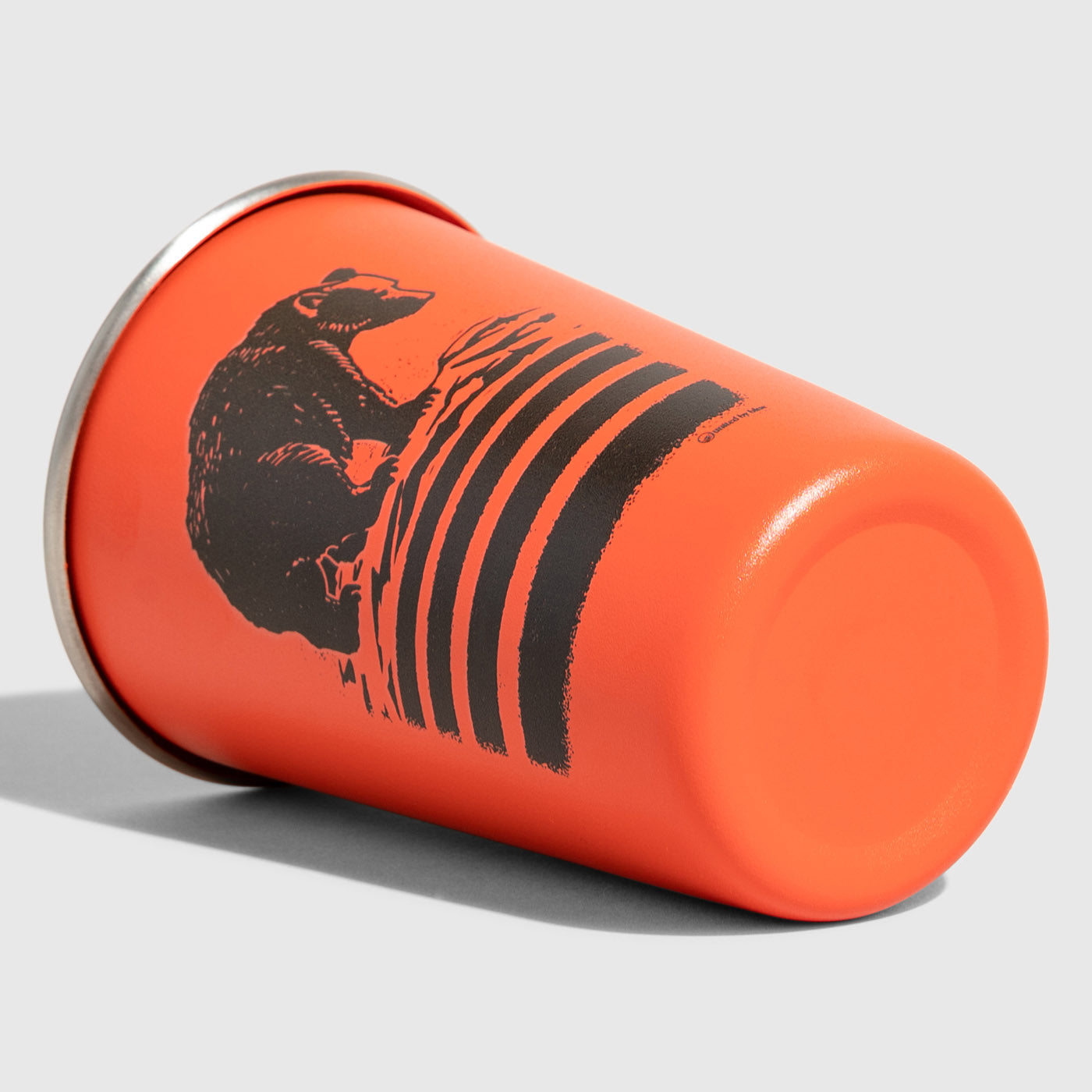 Orange Bears 16OZ STAINLESS STEEL TUMBLERS (Angle): Orange metal tumbler on its side, black bear and stripes graphic