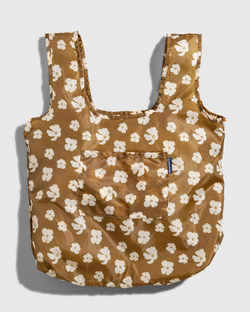 Smoky Ochre The Packable Tote (Flat-lay): Golden brown tote with white floral print, wide straps, and front pocket