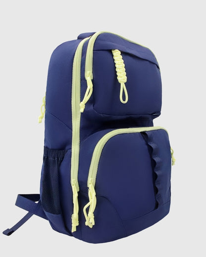 Blue (R)evolution™ 25L Transit Pack (Angle): Navy blue backpack with yellow-green zipper trim and paracord pulls