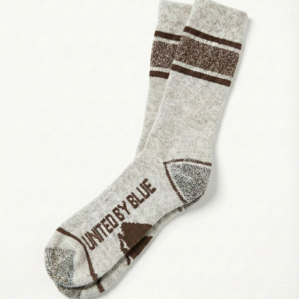 Coffee Ultimate Bison Boot Sock - Imperfect Packaging (Flat-lay): Light gray crew sock with brown stripes, heel, toe, and logo