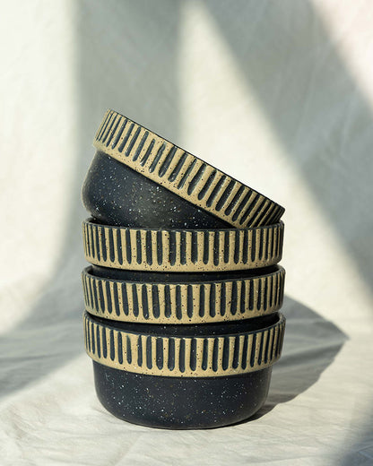 Slate Stoneware Stackable Bowl (Angle): Four dark speckled bowls stacked, wide rims with carved vertical stripe pattern