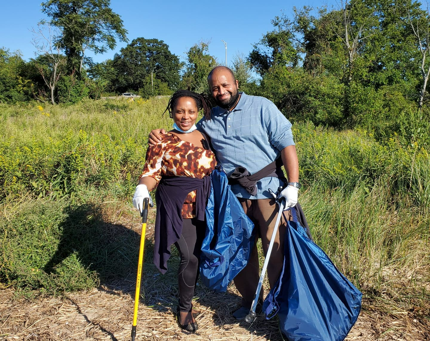 Navy Reusable DIY Cleanup Kit (In-use): Two volunteers holding navy blue trash bags and litter picker outdoors