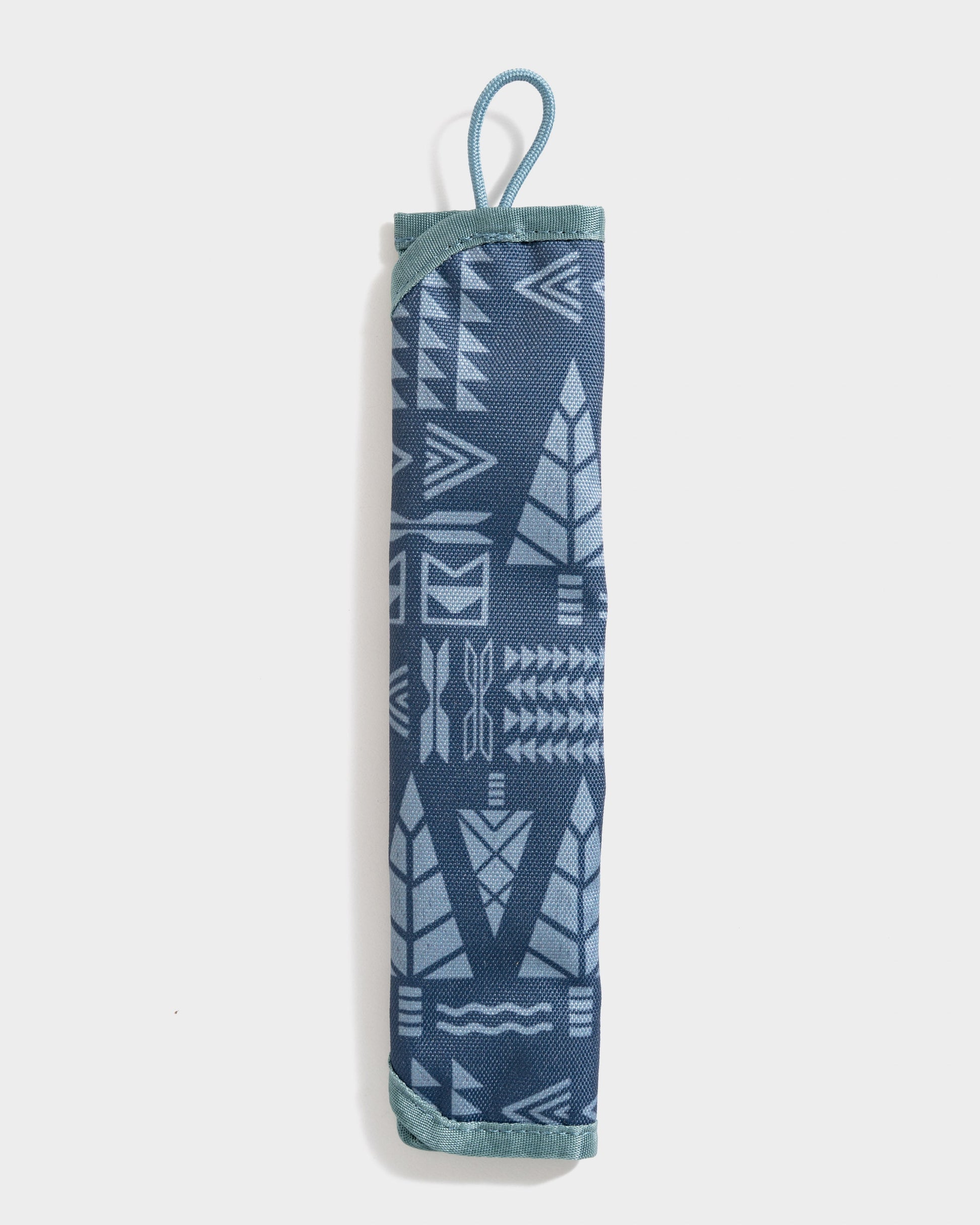Navy The Straw Kit (Front): Rolled navy fabric case with geometric arrow print and teal loop handle