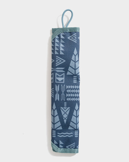 Navy The Straw Kit (Front): Rolled navy fabric case with geometric arrow print and teal loop handle