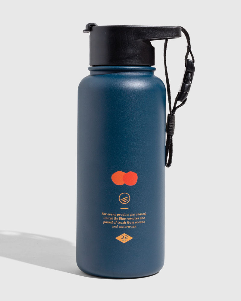 Lake - Waves Bottle - 23 Oz. Insulated Stainless Steel (Angle): Navy blue insulated bottle with orange graphic, black cap and wrist strap