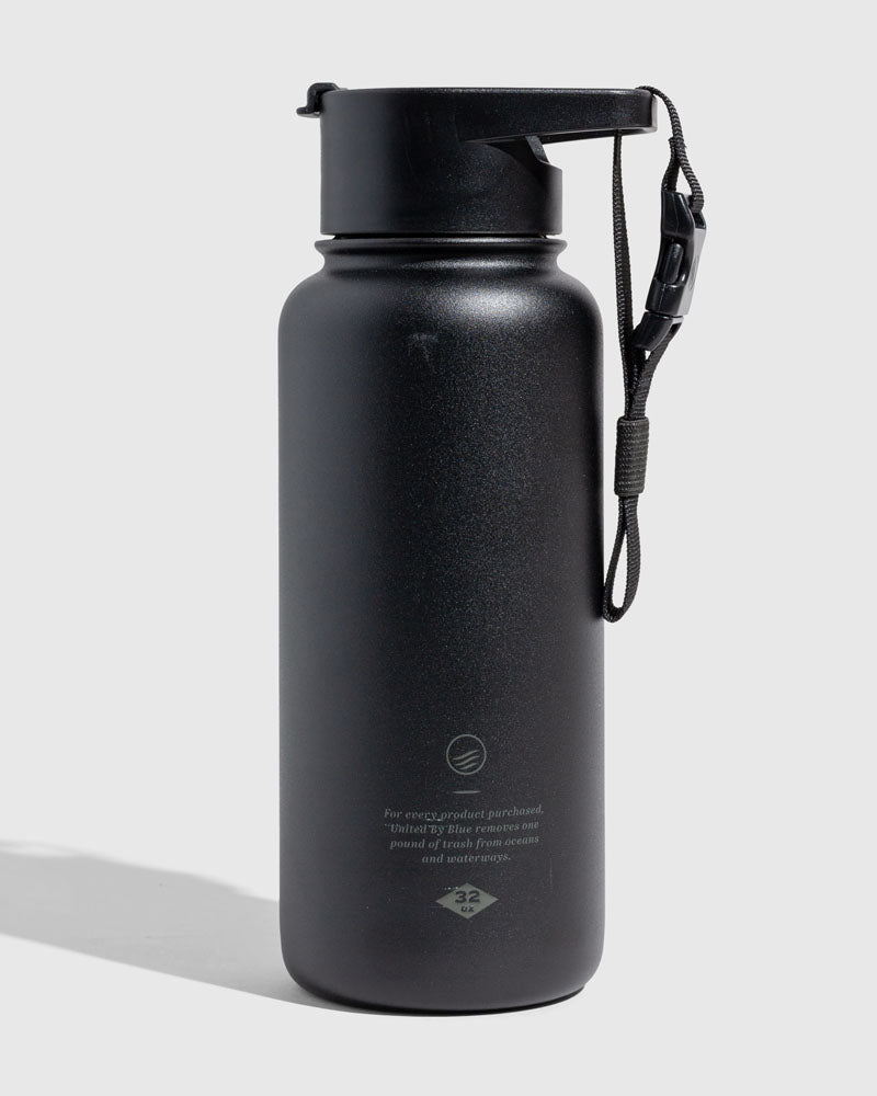 Black - Ink Bottle - 23 Oz. Insulated Stainless Steel (Angle): Matte black insulated bottle with flip-top lid and wrist strap attached