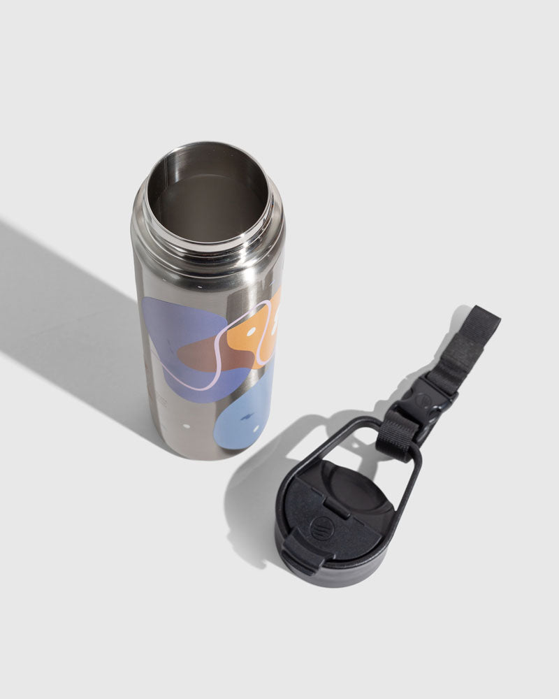 Illuminate Insulated Steel Bottle 32 Oz. (Angle): Open stainless bottle with abstract purple, orange, blue shapes; black lid beside