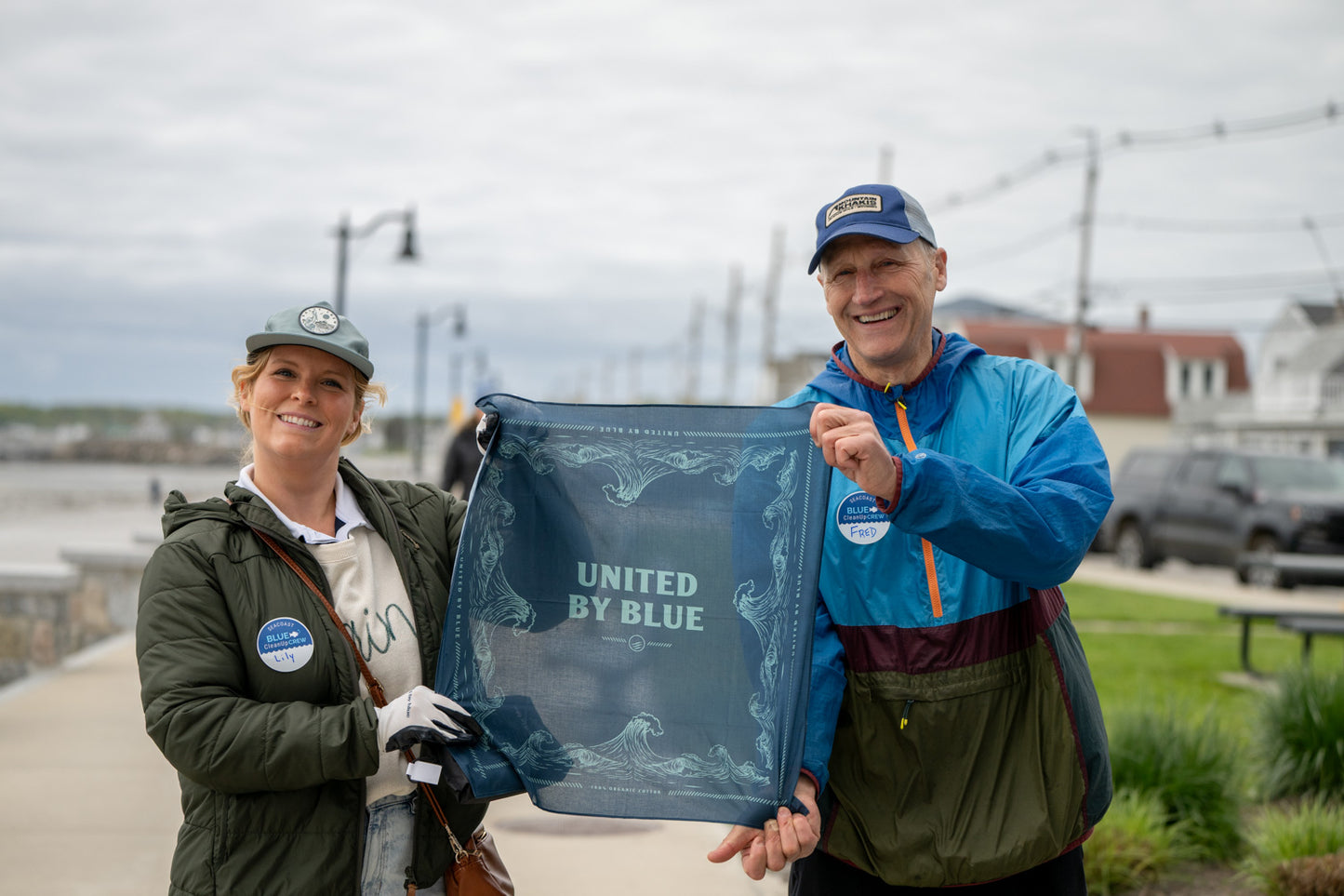 Navy Reusable DIY Cleanup Kit (In-use): Two smiling volunteers hold open a navy blue bandana outdoors