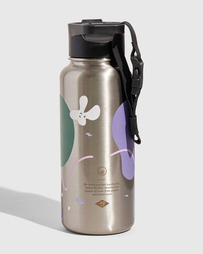 Illuminate Bottle - 23 Oz. Insulated Stainless Steel (Angle): Silver steel bottle with green, purple, white floral shapes and black strap