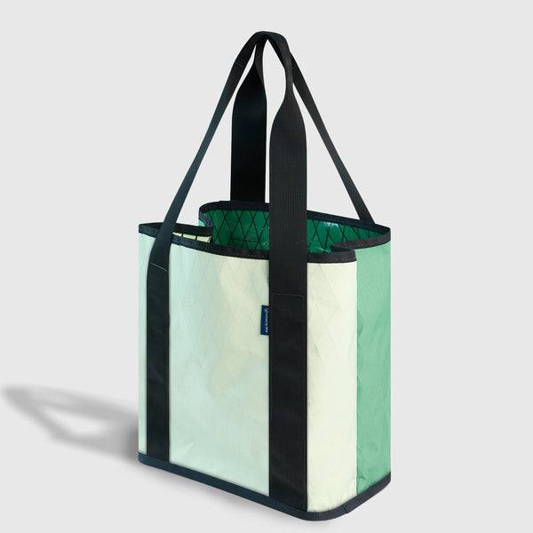 Evergreen The Westward Tote (Angle): Mint and cream tote with black straps, trim, and quilted green interior