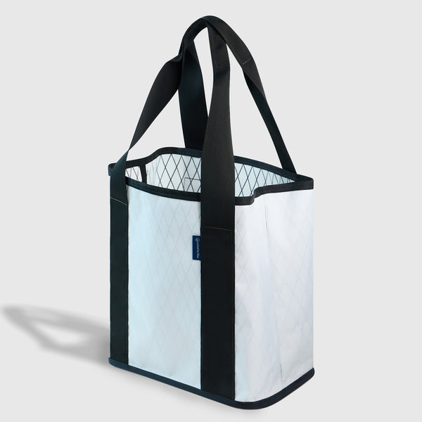 White The Westward Tote (Angle): White quilted tote with black trim, handles, and small blue logo tag