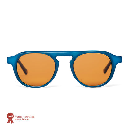 Blue-framed sunglasses with orange lenses on a white background, featuring an award badge.