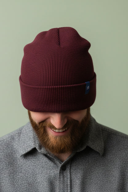 Burgundy Classic Yak Beanie (In-use): Dark red ribbed knit beanie pulled low over eyes on smiling bearded man