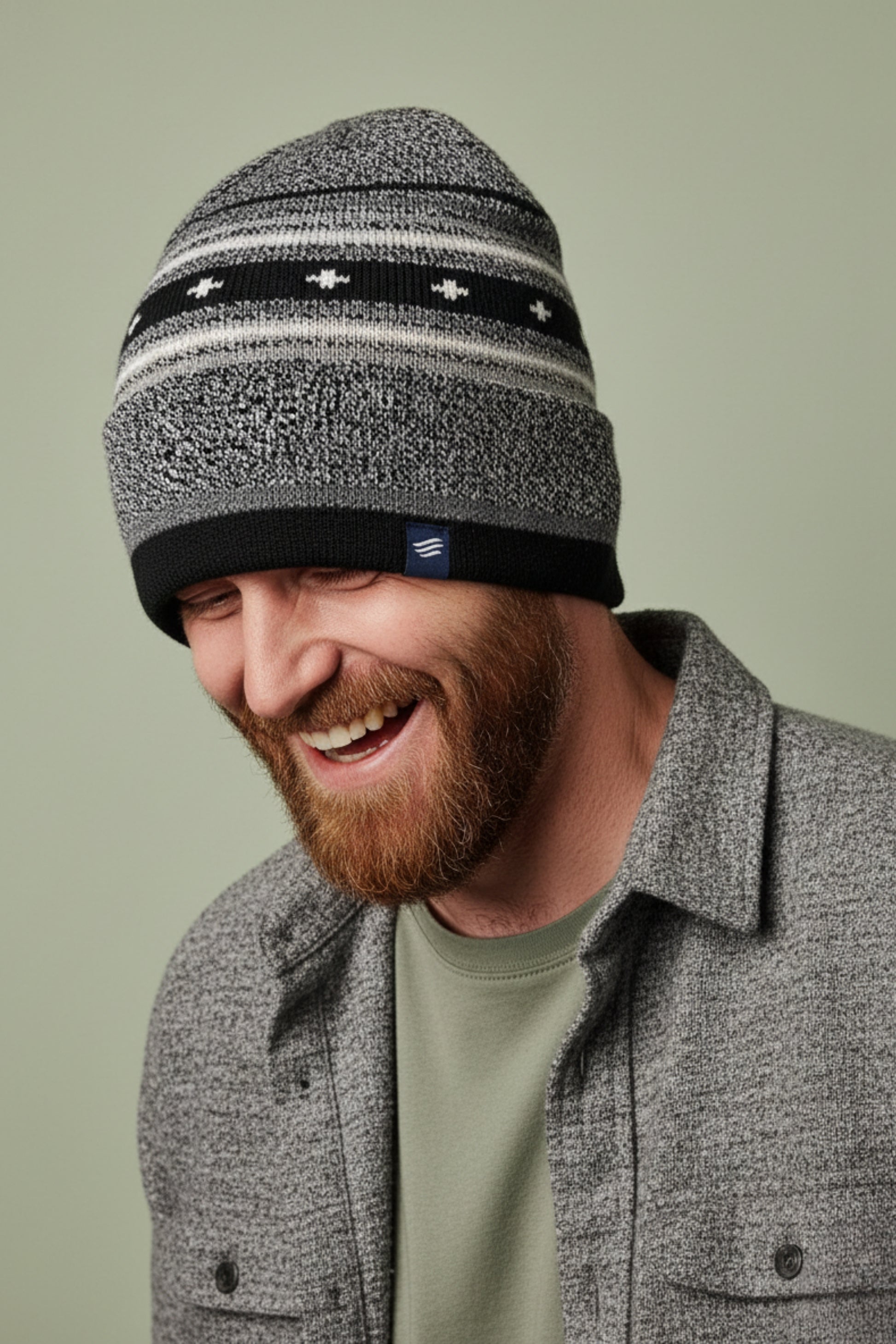 Black Merino Wool Slouchy Modern Fair Isle Beanie (In-use): Smiling bearded man wearing black and grey striped knit beanie outdoors