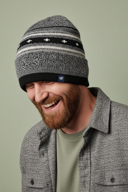 Black Merino Wool Slouchy Modern Fair Isle Beanie (In-use): Smiling bearded man wearing black and grey striped knit beanie outdoors