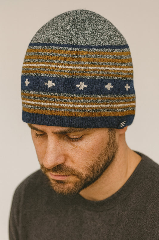 Navy Merino Wool Slouchy Modern Fair Isle Beanie (In-use): Bearded man wearing striped knit beanie with navy, gold, and grey pattern