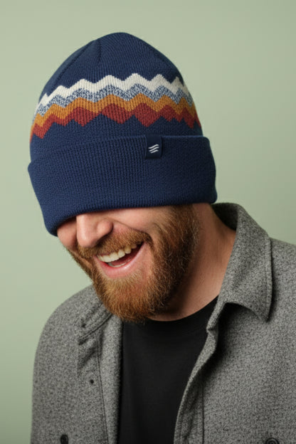 Navy Merino Wool Mountain Scape Knit Beanie (In-use): Laughing bearded man wearing navy beanie with chevron stripe pattern pulled low