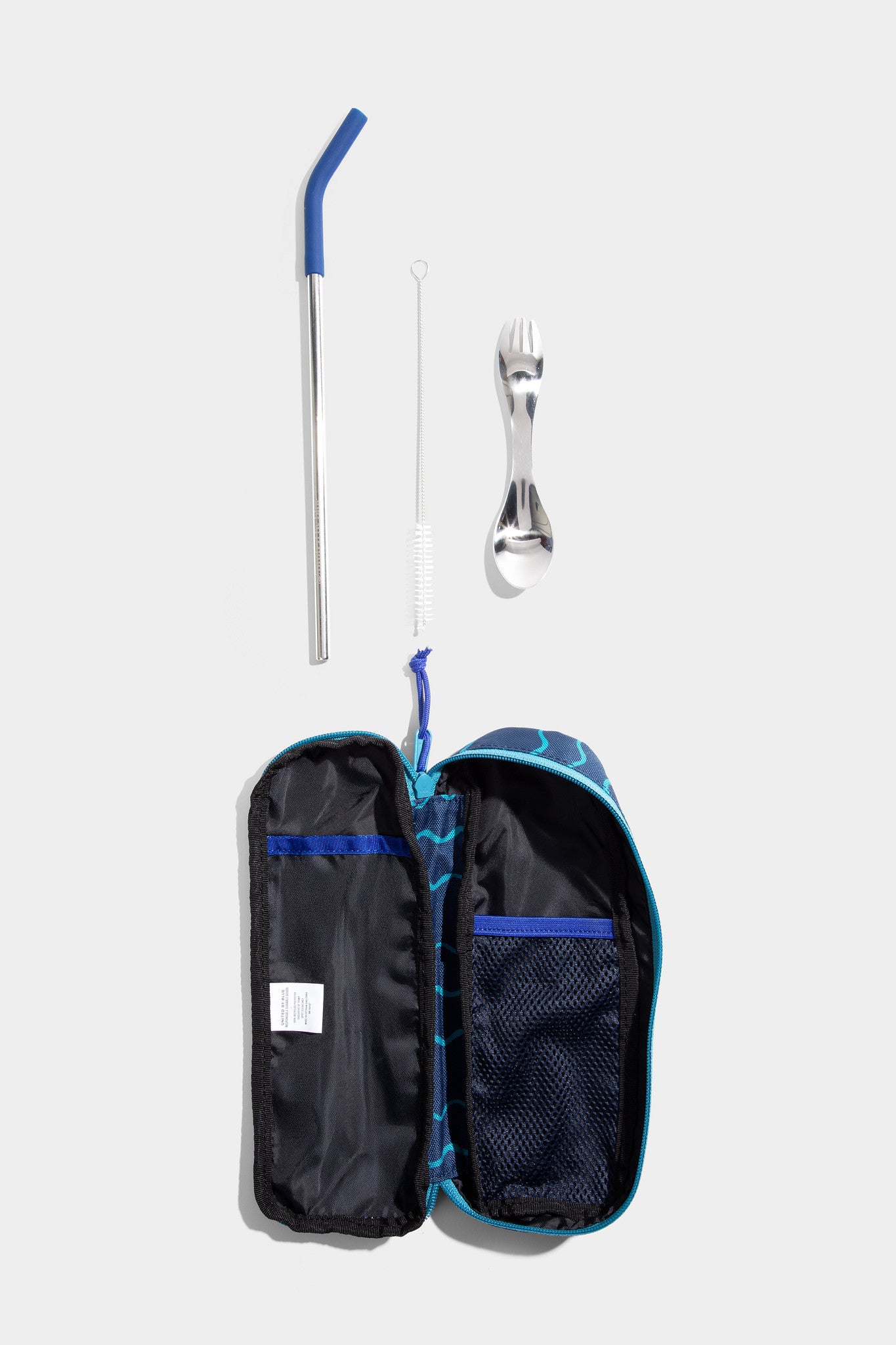Navy - Geo Waves The Utensil Pack - Perfect for Packed Lunches (Flat-lay): Open navy geo-print case with stainless straw, cleaning brush, and spork