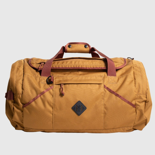 Camel (R)evolution™ 55L Carry-On Duffle (Front): Tan canvas duffle with burgundy straps, front zip pocket, and diamond logo patch