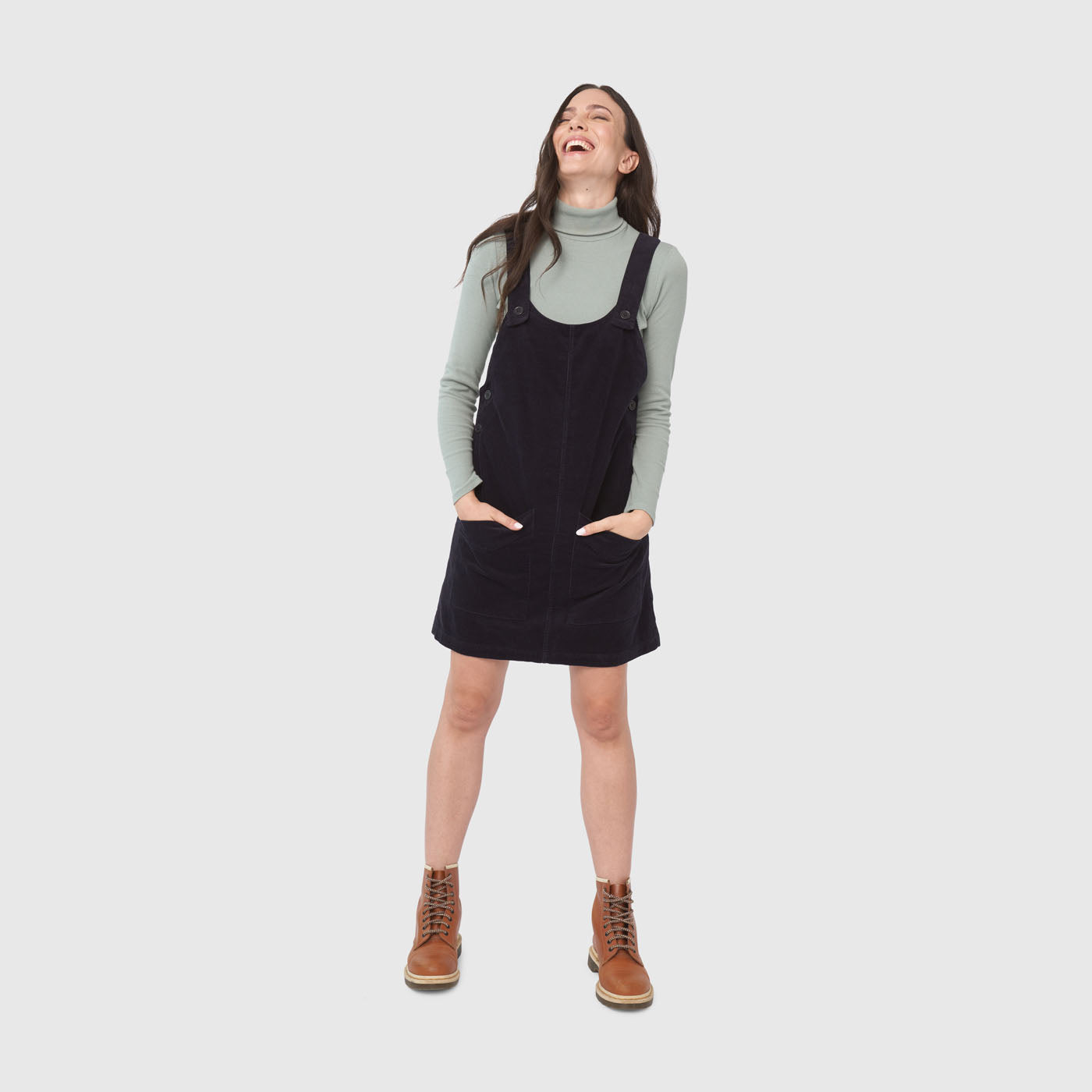Night Sky Corduroy Overall Dress (In-use): Dark corduroy pinafore dress with straps, pockets, worn over sage turtleneck