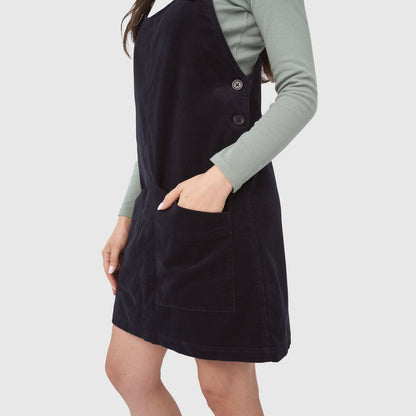 Night Sky Corduroy Overall Dress (Angle): Dark navy corduroy pinafore dress with front pocket and side buttons