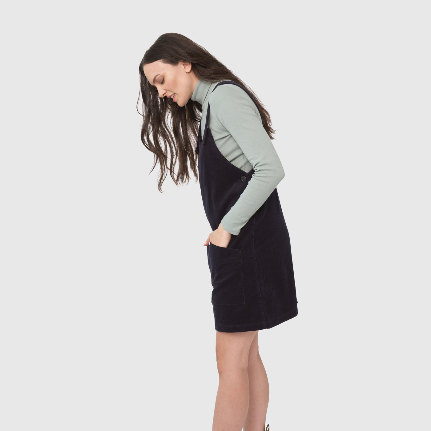 Night Sky Corduroy Overall Dress (Side): Dark navy corduroy pinafore dress with pockets, worn over mint turtleneck